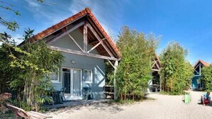 En række hytter med sandgrund, omgivet af bambusplanter.