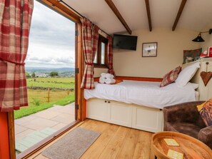 A bedroom with a bed, a television, a view of the countryside, and a wooden floor. - The Herdsman, Barnoldswick (Barnoldswick)