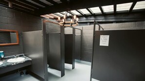 Des toilettes dotées d’un comptoir en marbre, d’un miroir et d’un luminaire au plafond.