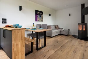 A modern living space with a dining area, sofa, and fireplace.