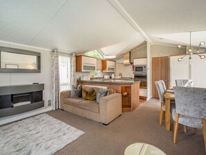 A compact living space with a sofa, dining table, and kitchenette. - Links Lodge, Flookburgh (Grange-Over-Sands)