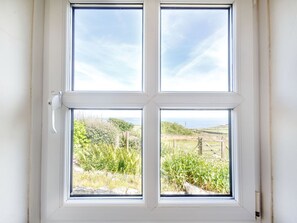 A window with a view of a rural landscape, including fields and trees. - CONION GANOL: Stunning Views (Pwllheli)