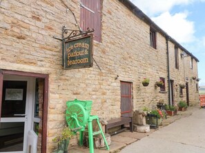 A stone building with a sign for an ice cream parlour and tearoom.