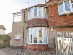 A corner bay window with white frames, a brick exterior, and a gravel driveway. - Southpoint, Bridlington (Bridlington)