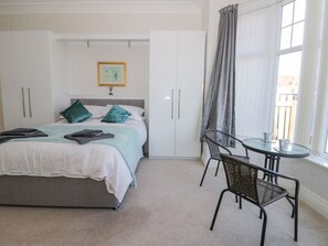 A bedroom with a bed, a chair, a table, and a window with curtains. - Southpoint, Bridlington (Bridlington)