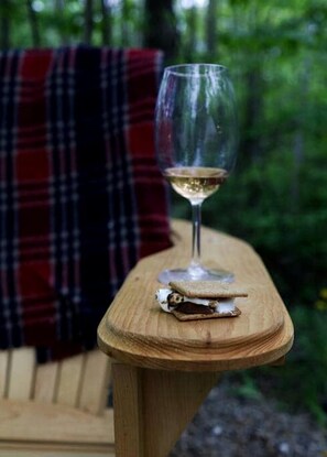 A glass of white wine on a wooden table with a sandwich.