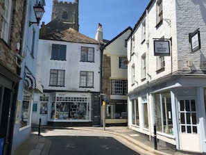 Straßenansicht mit einer Bäckerei namens 'Cornish Bakery' und einem Geschäft namens 'Fowey'.