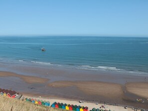 A beach with colorful beach huts and a clear view of the sea. - Pipit House, Whitby, North Yorkshire (Whitby)