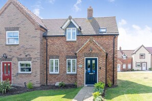 A two-story brick house with a red door, a blue front door, and a small porch. - Lilipad Cottage, Filey (Filey)