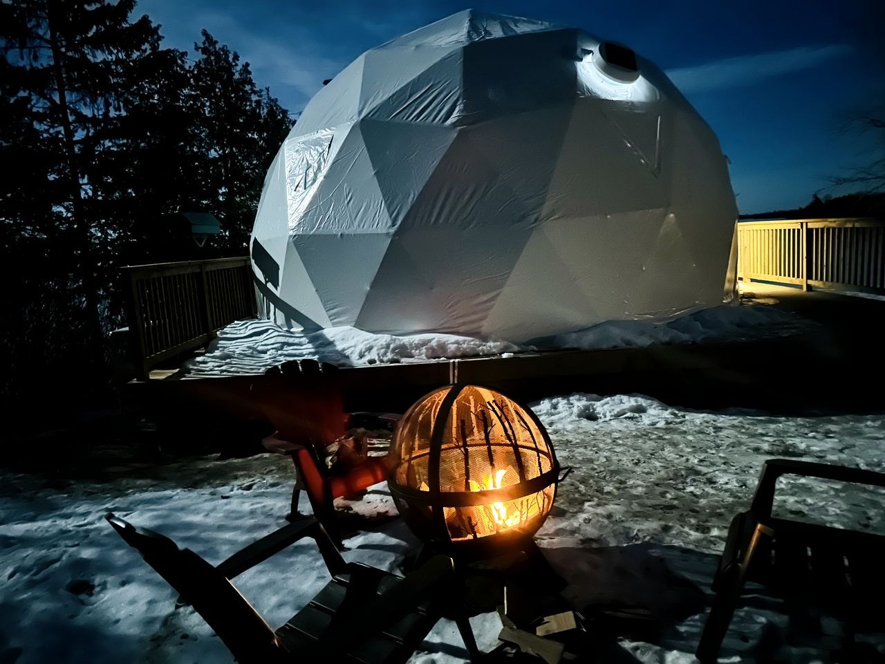 A geodesic dome structure with a spherical light fixture in the foreground.