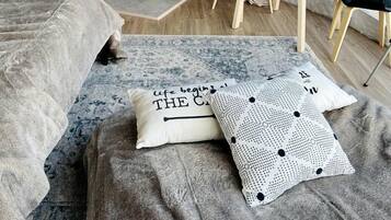 Une pièce accueillante aménagée comme une tente, avec un lit, une table sur laquelle se trouvent une bouteille et des verres, une cheminée et une vue par la fenêtre.