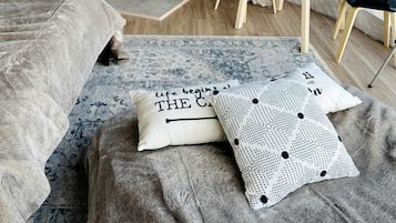 Une pièce accueillante aménagée comme une tente, avec un lit, une table sur laquelle se trouvent une bouteille et des verres, une cheminée et une vue par la fenêtre.
