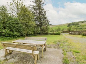 A picnic table and benches in a grassy area with trees and a stone wall in the background. - Prince's Cottage, Moniaive (Thornhill)