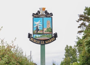 A welcome sign with a windmill and a church, indicating a local landmark. - The Annexe, Burgh Le Marsh (Skegness)