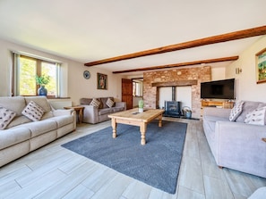 A living room with two sofas, a coffee table, a fireplace, and a television. - The Linhay, Washford (Watchet)