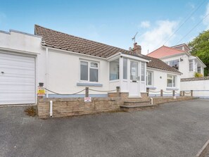 A residential property with a white exterior, a tiled roof, and a gated driveway. - Captiva Cottage, Saundersfoot (Saundersfoot)