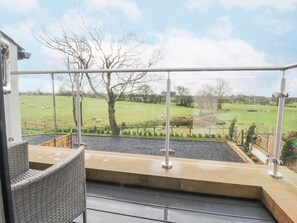 A balcony with a view of a grassy field and trees. - Apple Tree Cottage, Goosnargh. (Preston)