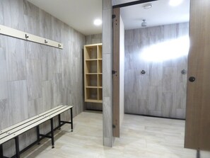 Ein Zimmer mit einer Holzbänkl, einer eingebauten Ablage und einer Tür zu einem weiteren Raum.