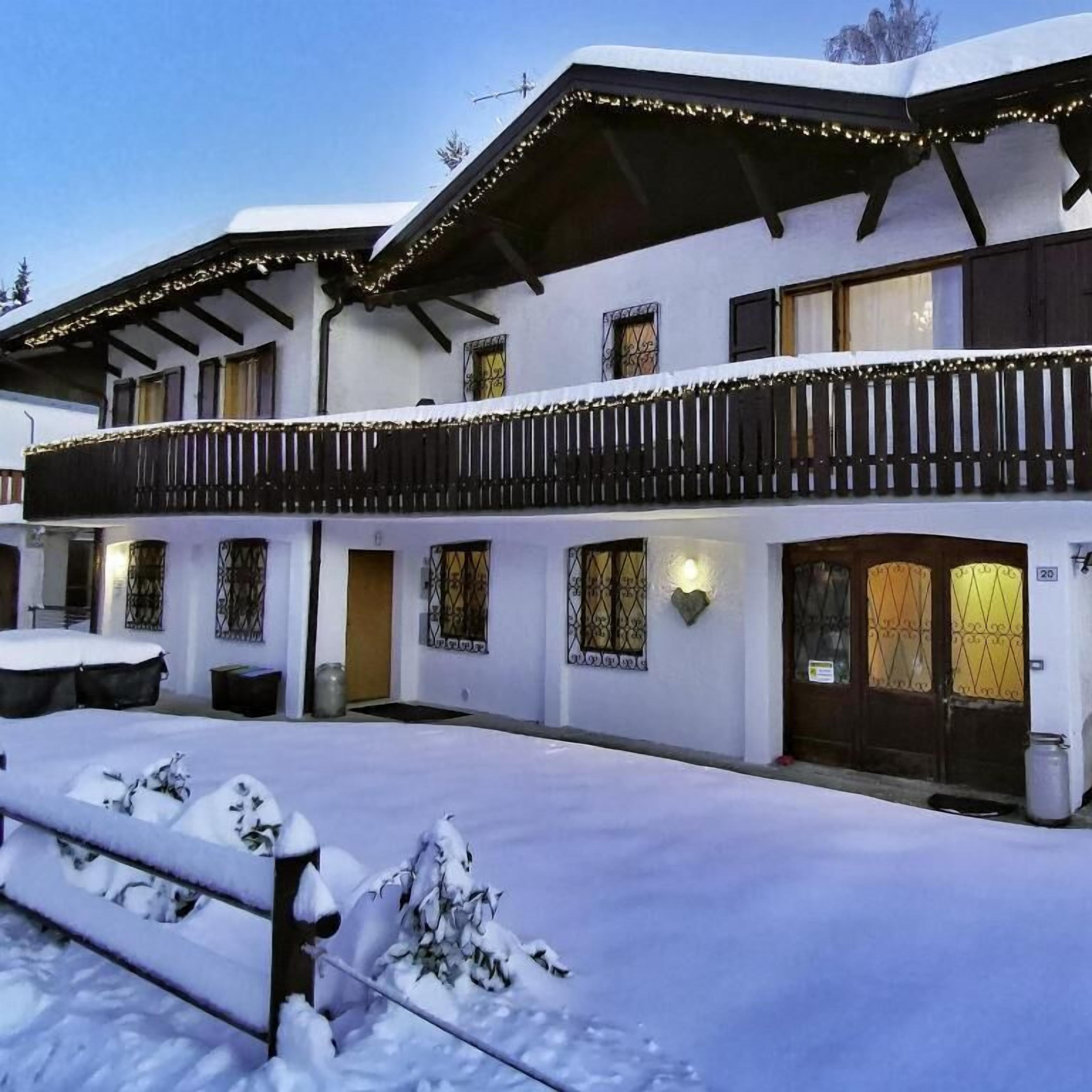 A two-story building with a balcony, snow-covered ground, and a sign indicating the number 30.