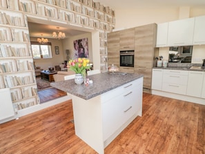 A modern kitchen with white cabinetry, a granite countertop, and a central island. - Cushat House, Embleton (Alnwick)