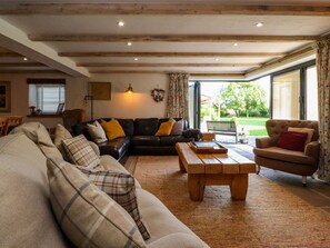 Ein gemütliches Wohnzimmer mit einer Couch, einem Holztisch und einem Sessel.