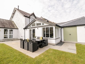 A house with a patio area, a dining table with chairs, and a garage. - Cooper's Rest (Gorffwysfa Coopers), Dolwyddelan (Dolwyddelan)