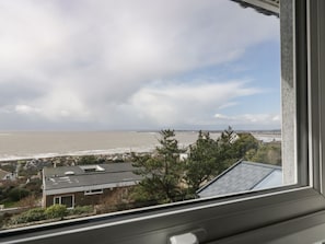 A view from a window overlooking a coastal area with houses and a beach.