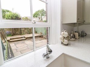 A kitchen with a window, a sink, and a countertop with kitchenware. - Toll House, Corbridge (Corbridge)
