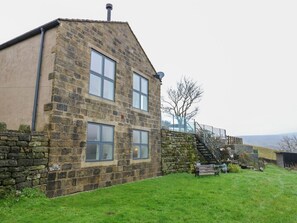 A stone building with two windows and a staircase leading to a higher level. - New Heights rests in Oxenhope. (Keighley)