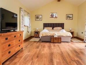 A bedroom with a bed, a television, a dresser, and a nightstand. - Deekswood: A Charming Retreat in Pilling (Preston)