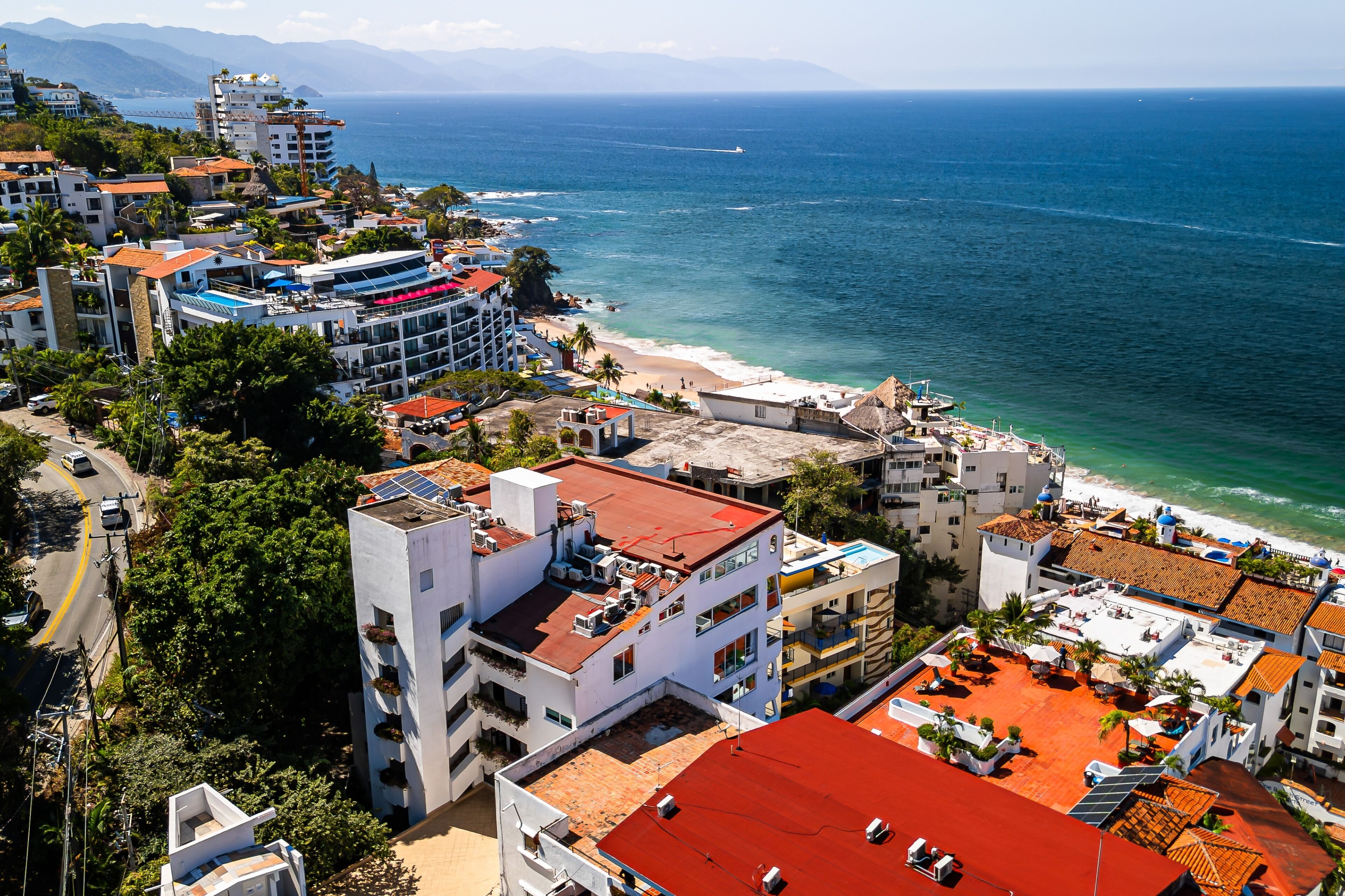 Un paysage urbain côtier avec des bâtiments, une plage et l’océan.