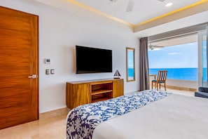 A hotel room with a large bed, a TV, a wooden desk, and a chair. - Blue Horizon 304 | 1BR Ocean View in PV w/ Pool (Puerto Vallarta)