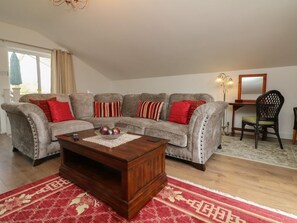 A living room with a sofa set, a wooden coffee table, and a patterned rug. - 40 Kingwood Forest Park, Devon (Umberleigh)