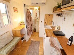 A compact kitchen with a sink, a microwave, and a wine bottle on the counter. - Shepherds Hut - Ash, Lincoln (Lincoln)