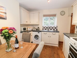 A compact kitchen with white cabinets, a washing machine, a microwave, and a sink. - Llwyn Celyn, Brithdir (Nr Dolgellau)