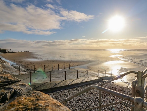A beach with a fence, pebbles, and a clear sky. - The Last Resort, Pendine (United Kingdom)