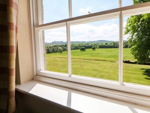 A window with a view of a green field and trees. - The Card House, Hopton (Matlock)
