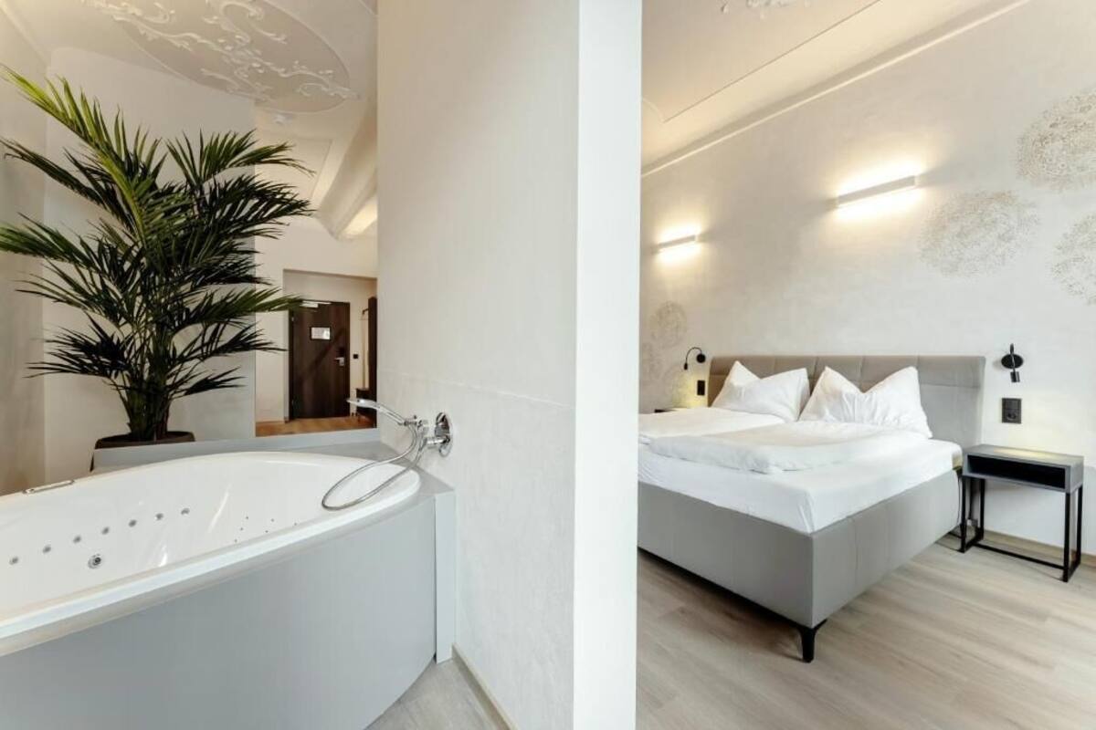 A modern bathroom with a bathtub and a potted plant.