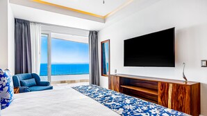 A hotel room with a large bed, a TV, a sofa, and a view of the sea. - Ocean-view Puerto Vallarta condo with pool, gym (Puerto Vallarta)