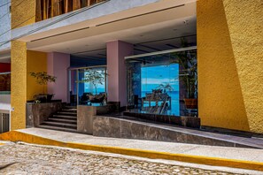 Ein Hotel mit Glastür, Außenbereich und einer Treppe zum Eingang.