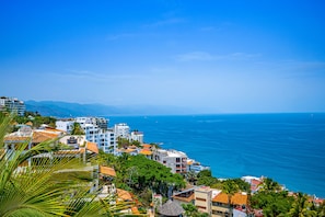 A coastal town with buildings, a clear blue sky, and the sea. - Gardenias Studio | Studio in Puerto Vallarta with panoramic views (Puerto Vallarta)