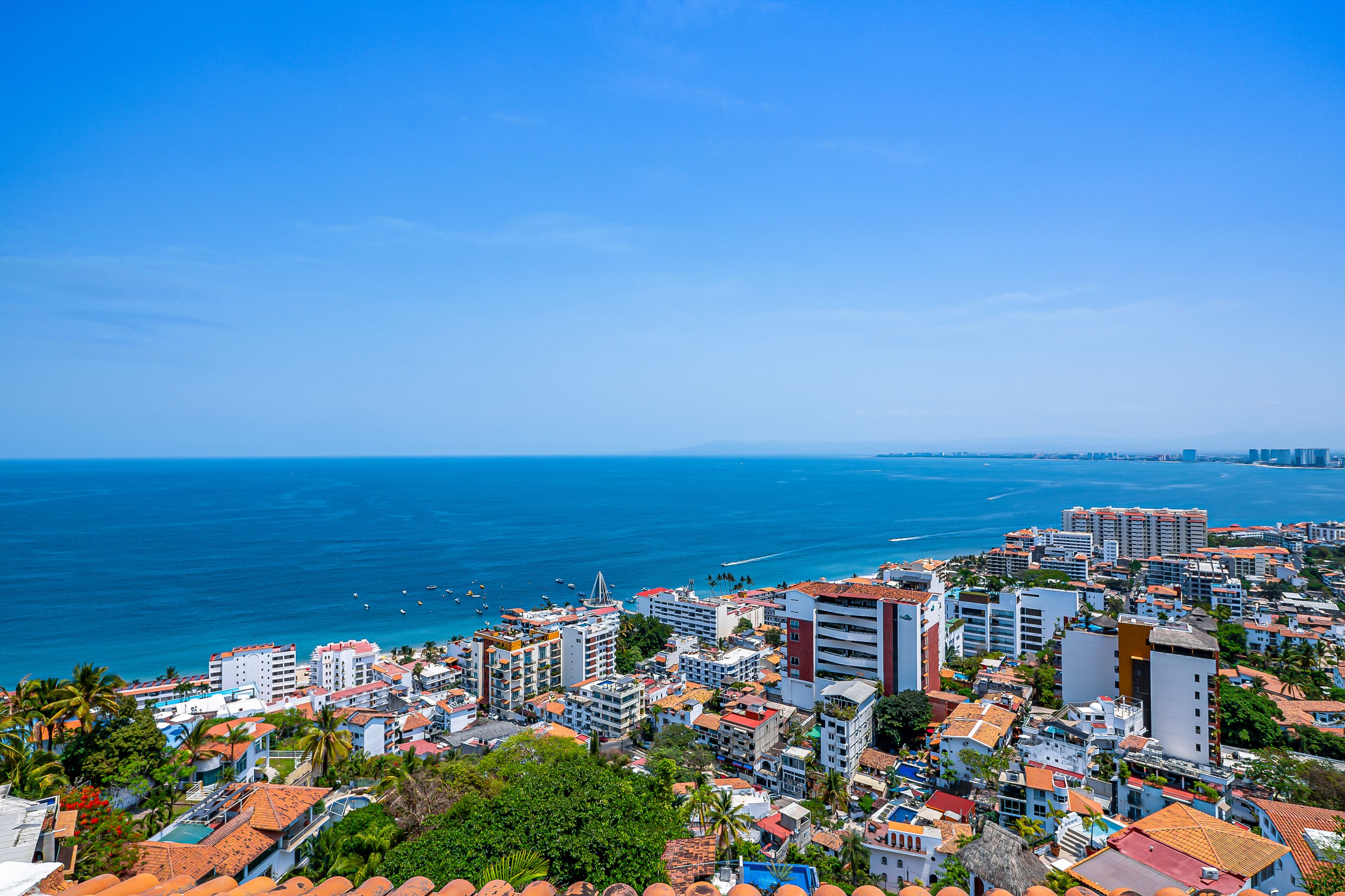A coastal cityscape with buildings, a beach, and the ocean.