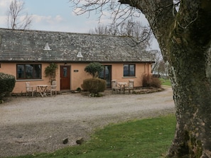 A single-story building with a gravel driveway, a front door, and a small patio area with two tables and four chairs. - Little Winder, Askham, Cumbria (Penrith)