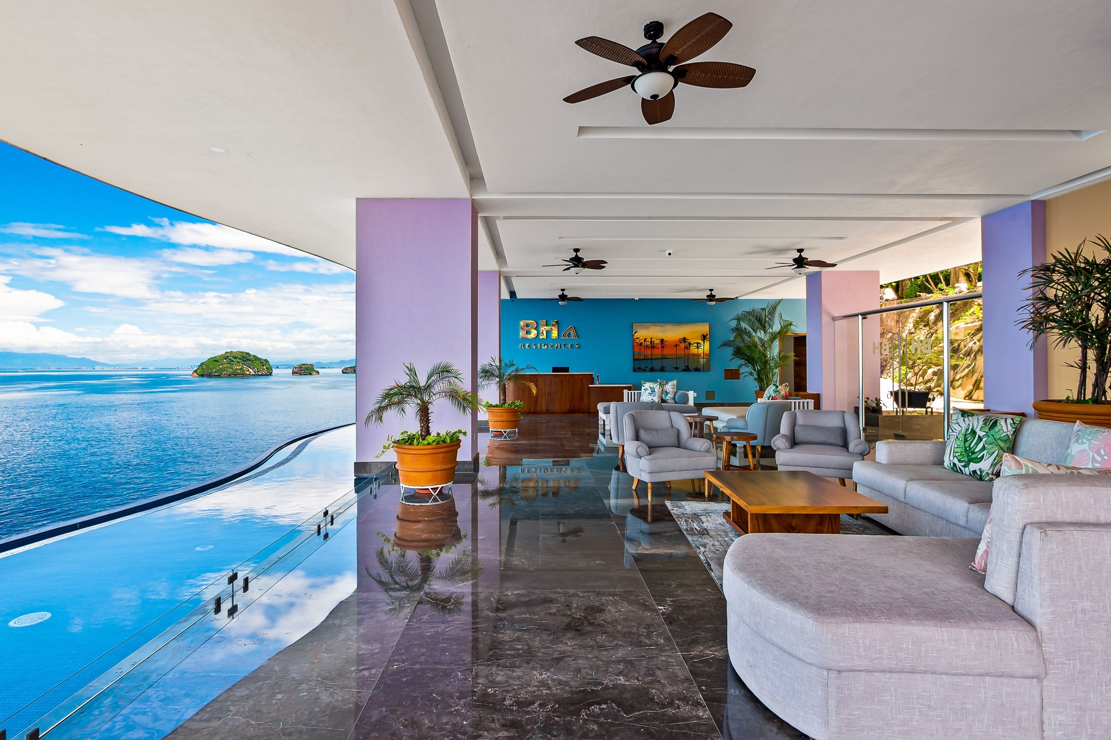 En rymlig lobby med utsikt över havet, en receptionsdisk och moderna sittgrupper.