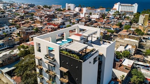 A modern building with a rooftop pool and a view of the sea.