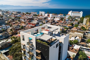 A modern building with a rooftop pool and a view of the sea. - 2BR/2BA 5 De Diciembre condo in Puerto Vallarta (Puerto Vallarta)