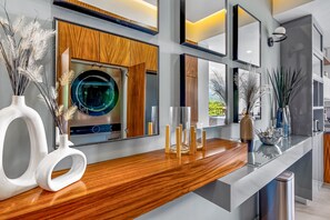 Una cocina moderna con encimeras de madera, lavadora integrada y jarrones decorativos.