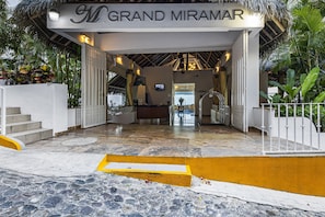 A hotel entrance with a sign reading 'GRAND MIRAMAR,' a reception desk, and a staircase leading inside. - Stunning oceanview suite with cliffside infinity pool, terrace & gourmet kitchen (Puerto Vallarta)