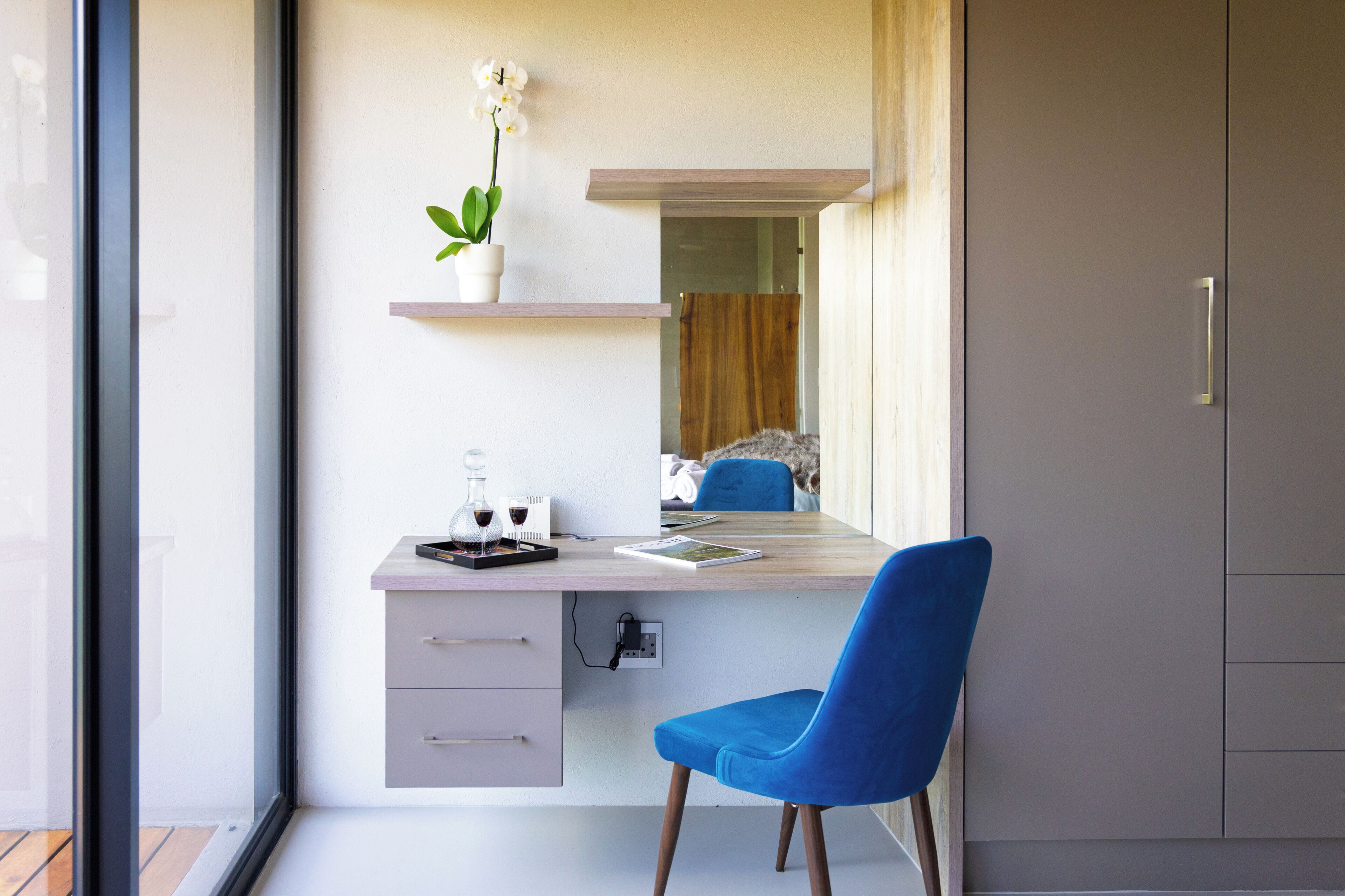 A modern office space with a desk, chair, and a potted plant.