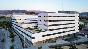 Un edificio moderno de varios pisos con techo plano, ventanas amplias y fachada uniforme.